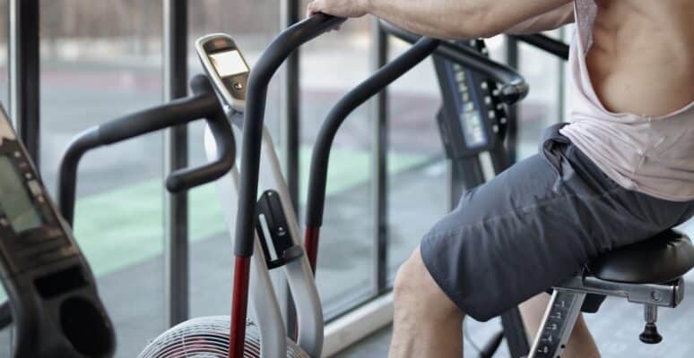 A man exercising on a bike at a gym.