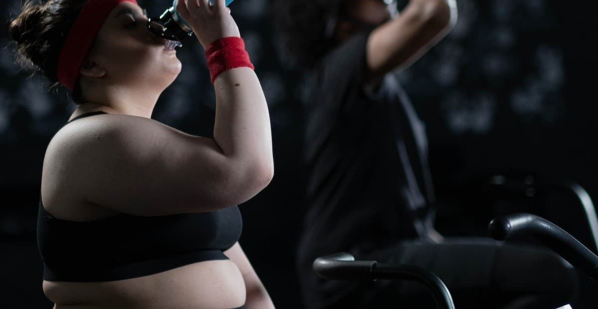 Man and woman drinking water after exercise