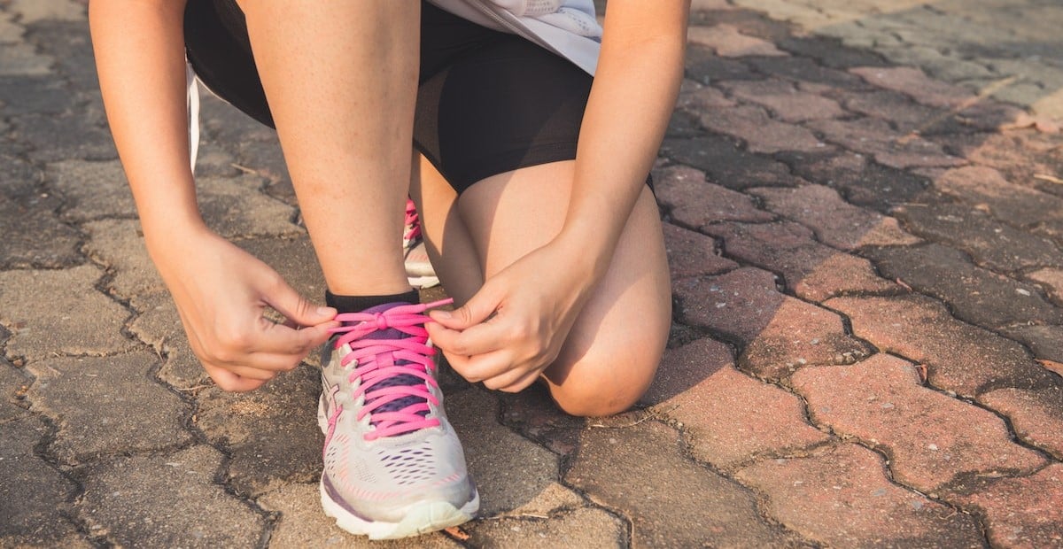 A woman lacing up her shoes
