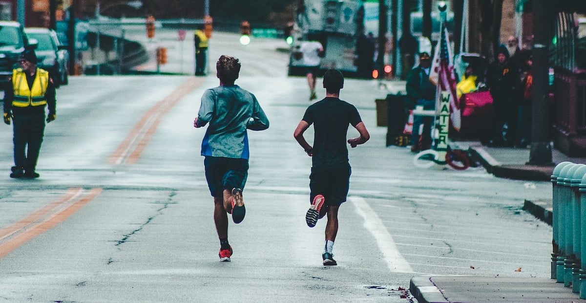 Two Men Running On Concrete Road